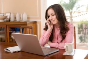 woman at home using phone and laptop